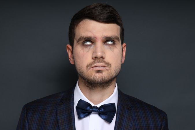 A man in a zombie costume on a dark background