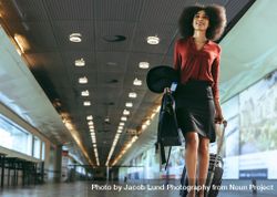 Female traveler walking through airport terminal 5aALa5