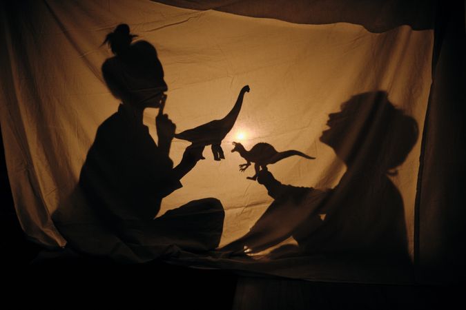 Mom and son playing with brachiosaurus in shadow theater