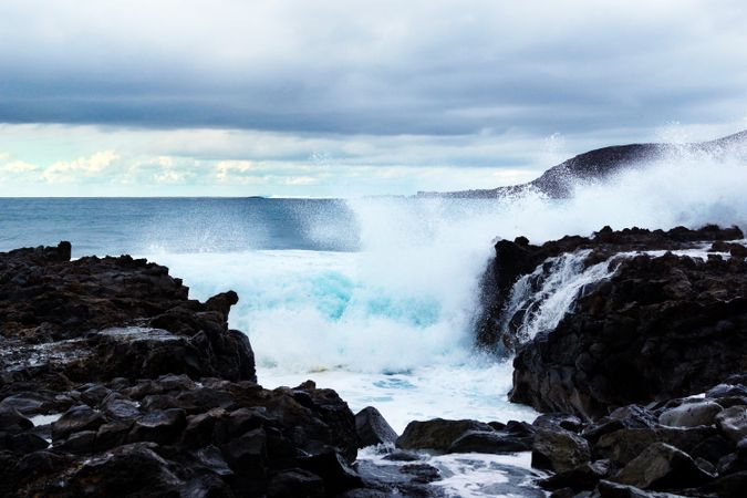 blue waves of ocean with foam texture against rocks