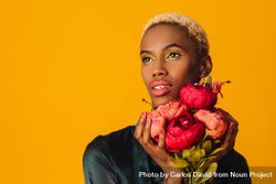 Black woman with short blonde hair holding bouquet of large red flowers 0Kp8V5