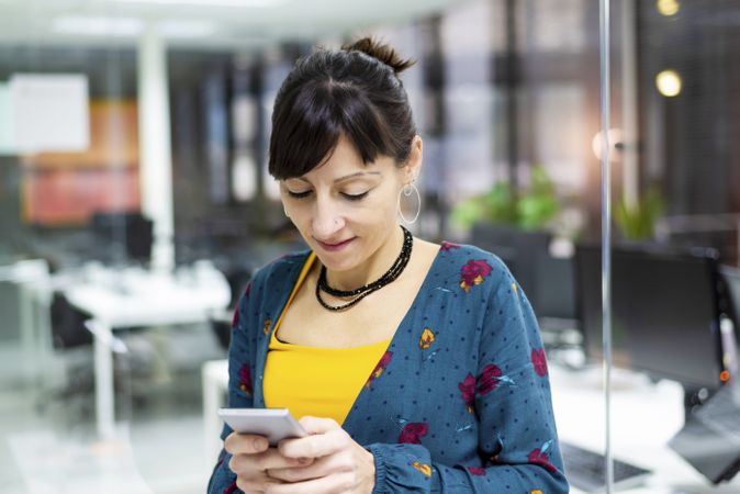 Woman browsing smartphone in office