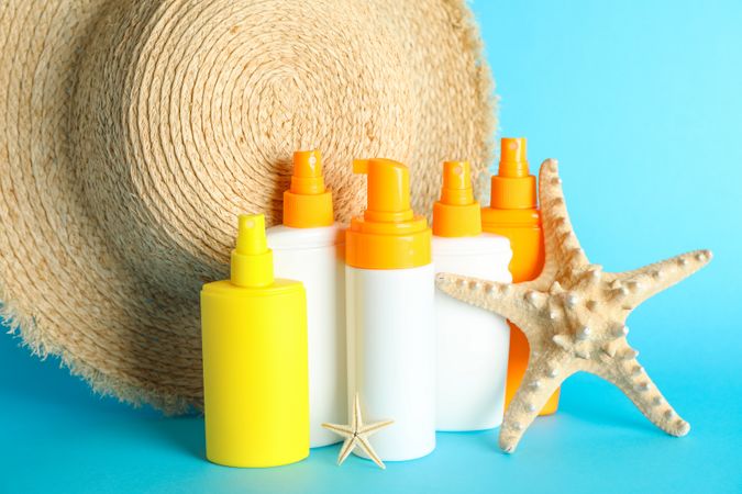 Summer vacation accessories on color background, closeup. Safe tan