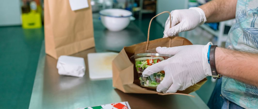 Unrecognizable cook packing a takeaway order