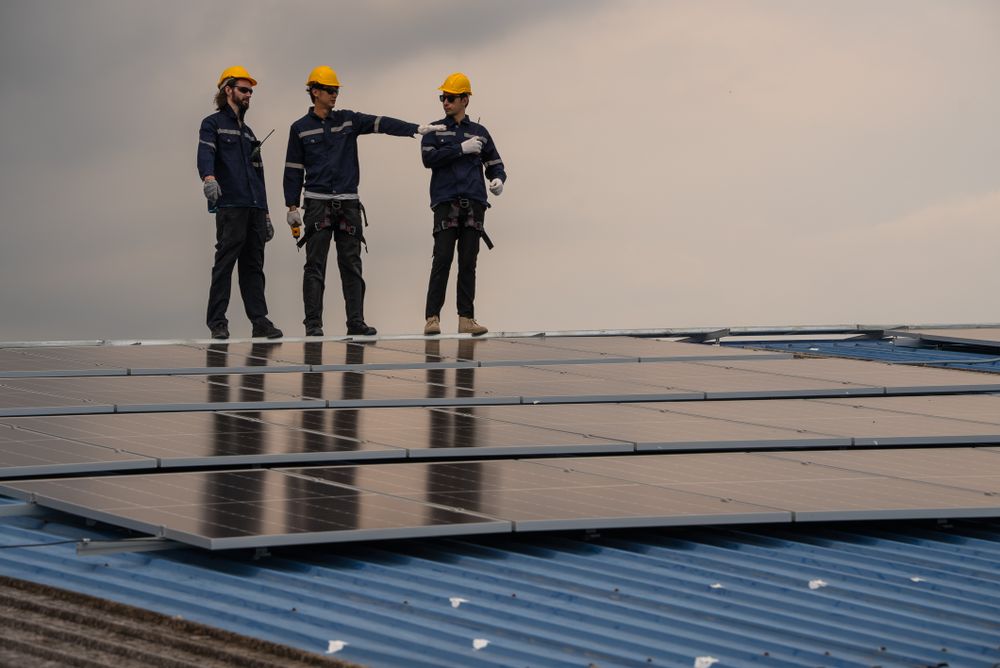 Engineer team checking solar cell  or photovoltaic cell installed on the roof of the factory. Technician worker repair or inspect the system. Industrial renewable energy concept