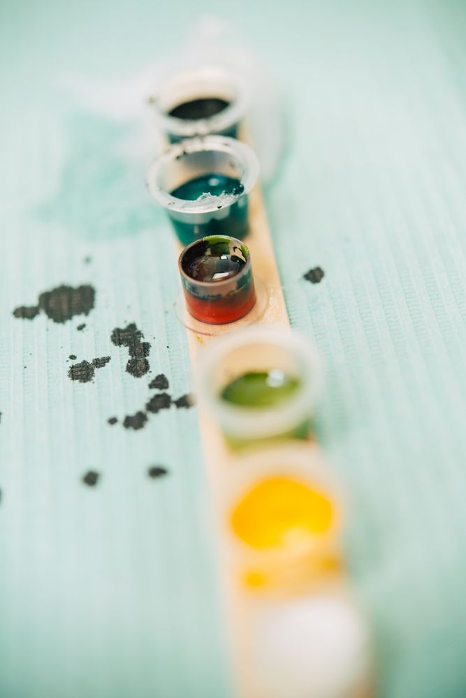 Row of small pots of ink for a tattoo