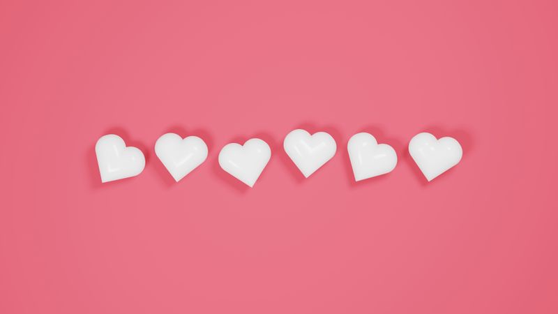 Plastic hearts on pink background
