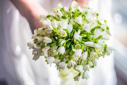 Bridge holding floral bouquet with snowdrops