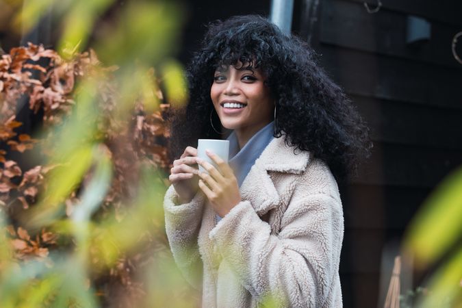 Smiling Black woman with cup of coffee