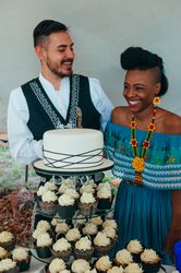Bride and groom laughing before cutting the wedding cake