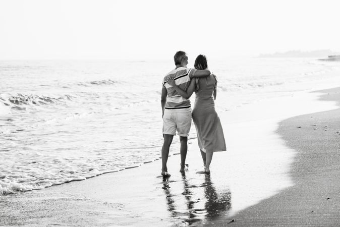 Adult couple walking towards sea