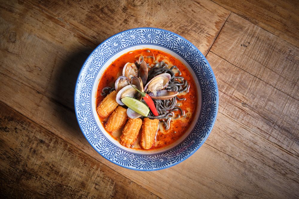 Typical hot ramen dish with fish broth in a bowl with noodles, squid, chilli, clams.