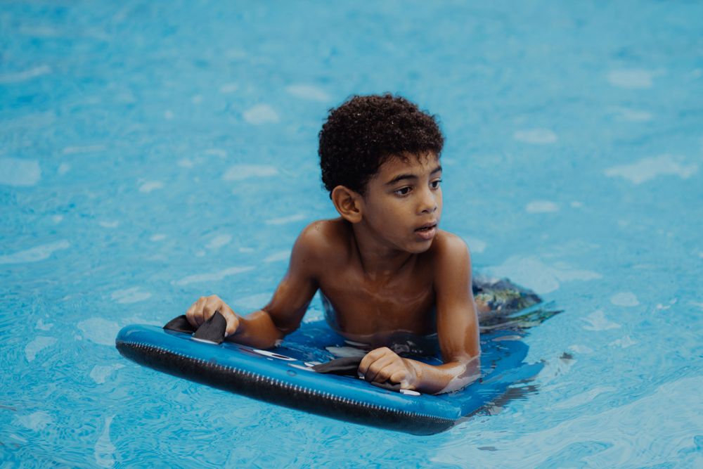 Black boy swimming in pool