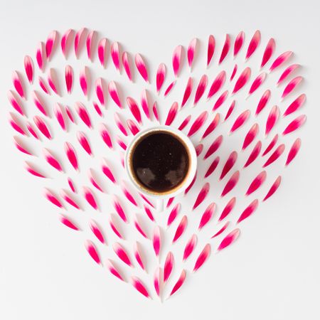Heart made of pink flower petals with coffee