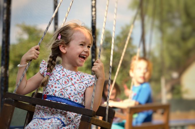 Smiling girl on carousel with other children