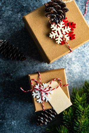 Top view of Christmas presents with decorative snowflakes and pine cones