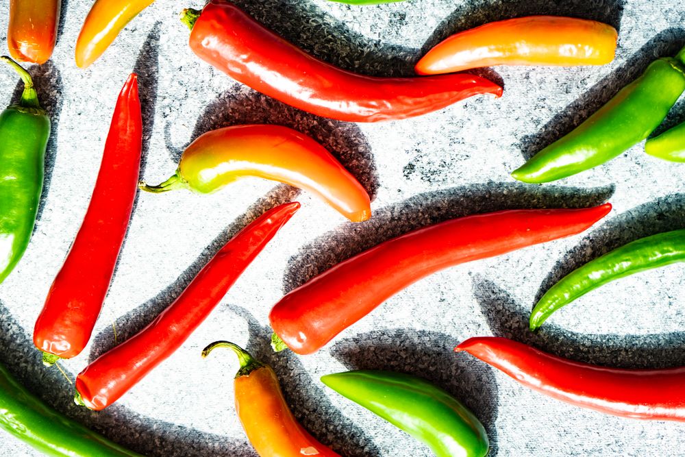 Top view of spicy peppers on grey kitchen counter