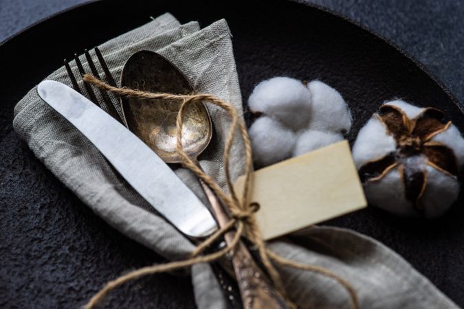 Top view of table setting with decorative cotton and feathers with napkin on plate