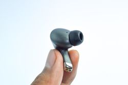 Hand holding wireless earbud