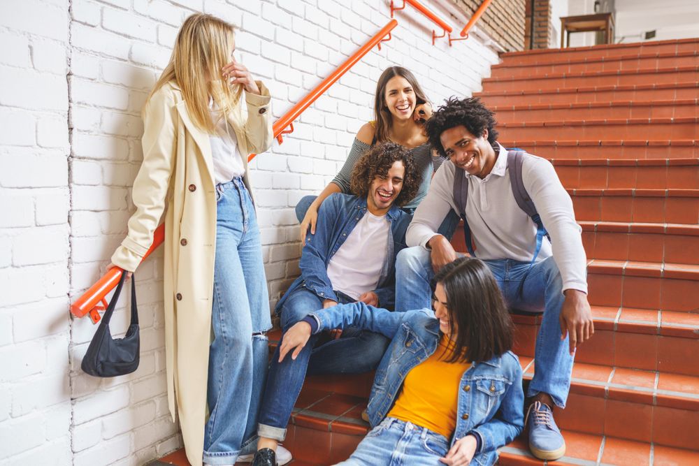 Smiling friends hanging out on brick steps