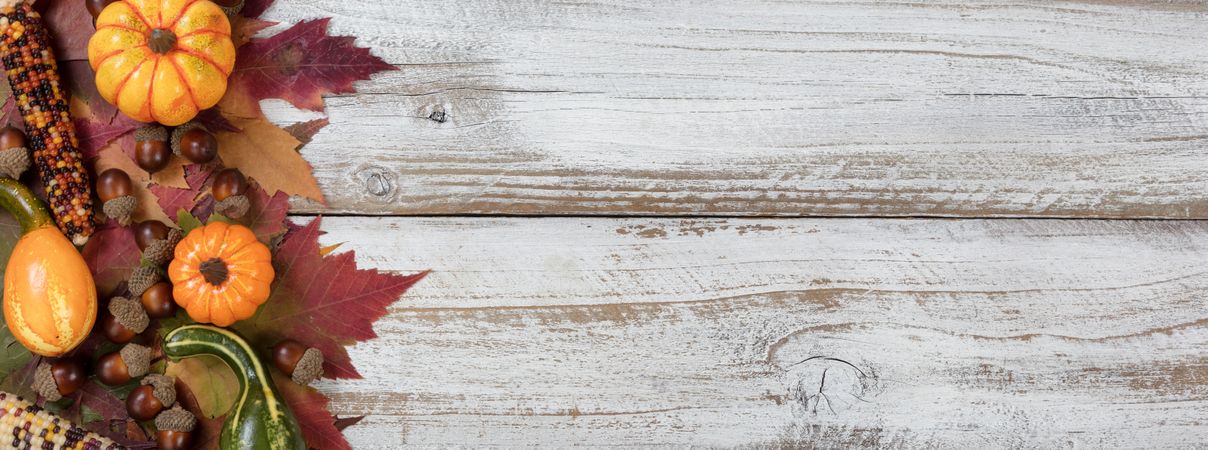 Autumn foliage with other fall decorations on rustic wooden boards
