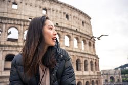 Cheerful Asian traveler outside famous landmark