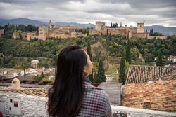 Content female enjoying view of big ancient castle
