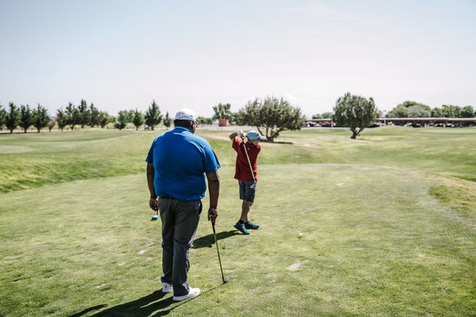 Back view of two men playing golf