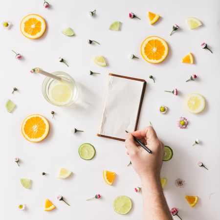 Colorful pattern made of orange, lemon, lime and flowers with hand writing on old notebook