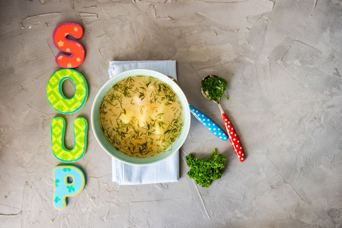 Bowl of healthy chicken soup on napkin with the word "soup"
