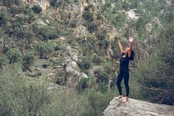 Happy female traveler raising arms and screaming