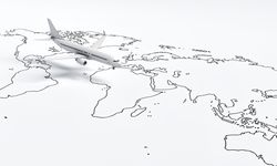 Wide shot of plane model going over drawn map travel plane