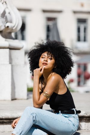 Black female sitting on stairs outdoors