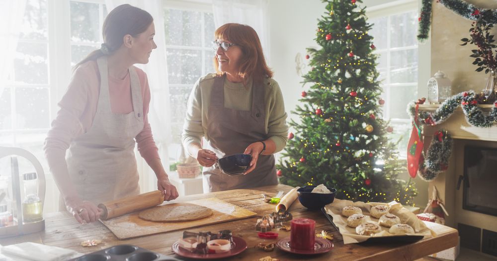 Portrait of Adult Woman Preparing Gingerbread for Christmas While her Older Mother is Helping.