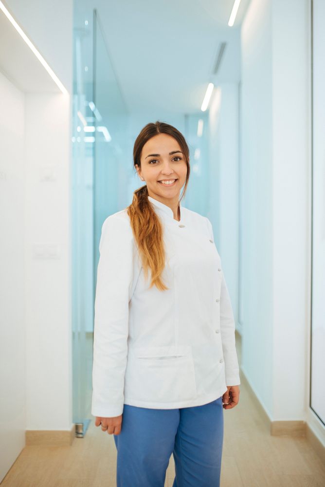 Confident dentist in uniform with crossed arms looking at camera
