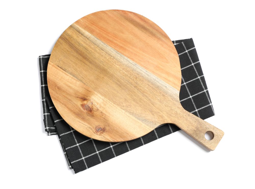 Cutting board with kitchen towel isolated on studio background, top view