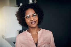 Portrait of woman wearing glasses holding glass of water