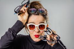 Woman with various glasses and red lips gesturing