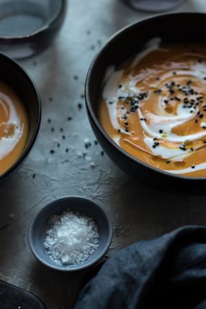 Bowls with pumpkin cream soup on table