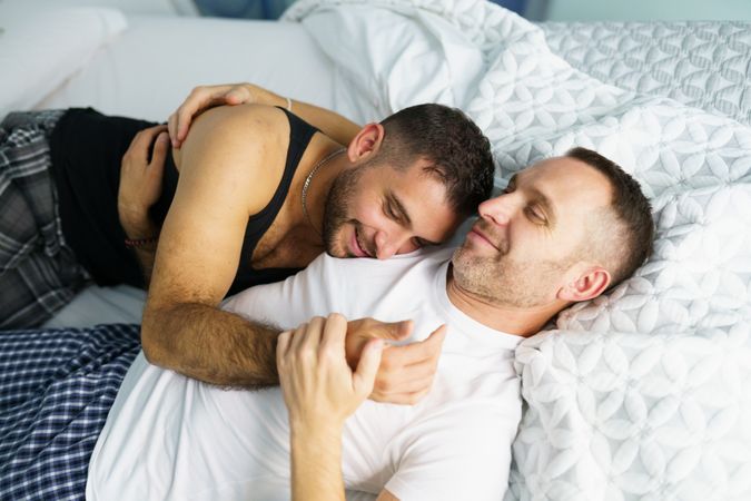 Male sleeping on his partners chest in bed