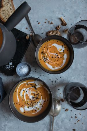 Bowls with pumpkin cream soup on table