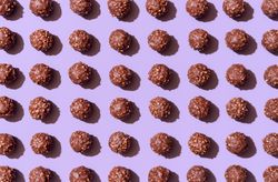 Chocolate candies aligned on a purple background