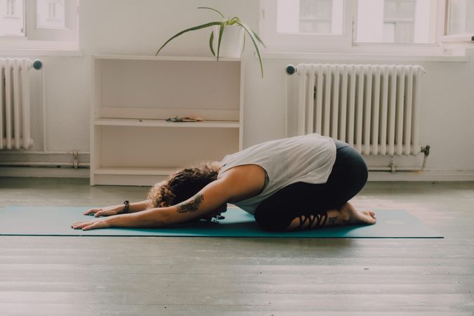 Fit woman practicing yoga at home