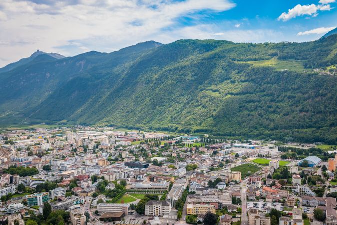 Densely populated town at foot of green mountains