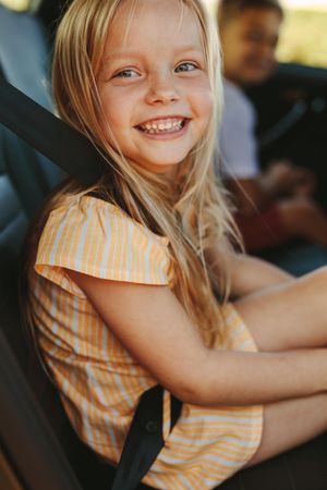 Cheerful girl enjoying travelling by a car