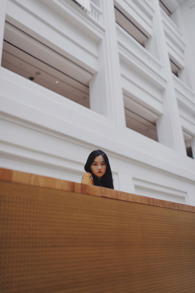 Woman in orange dress standing on balcony