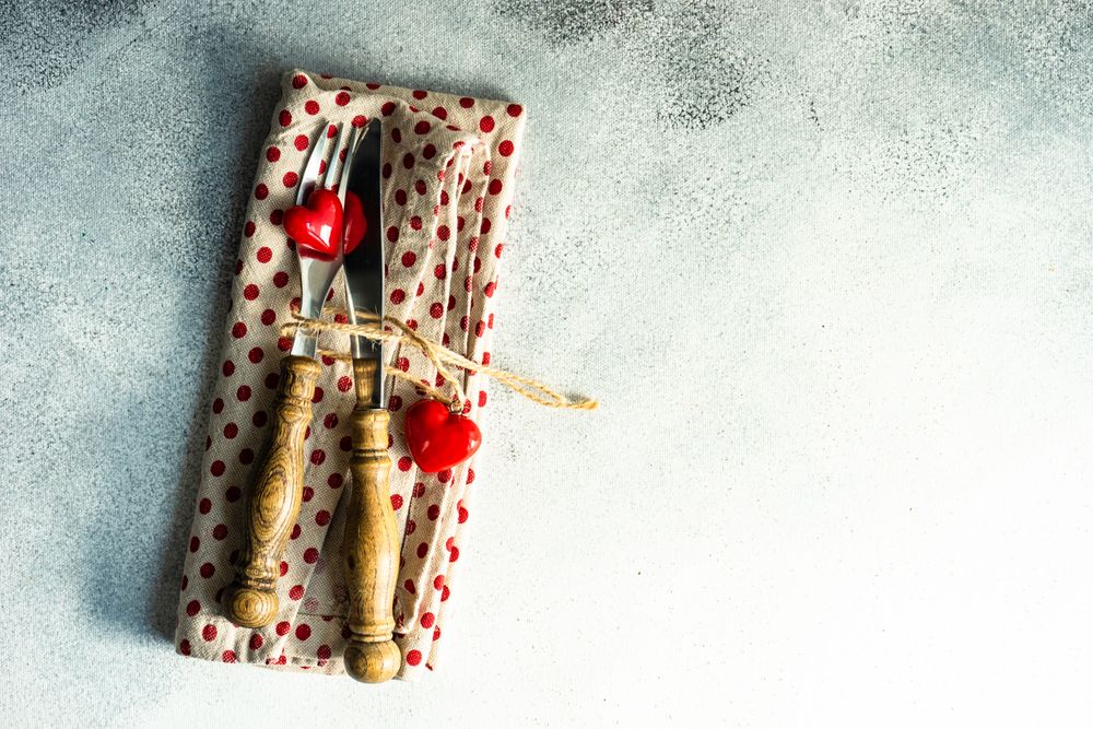 Silverware on dotted napkin with heart decorations with copy space