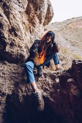 Neutral female hiker resting in rocky slope