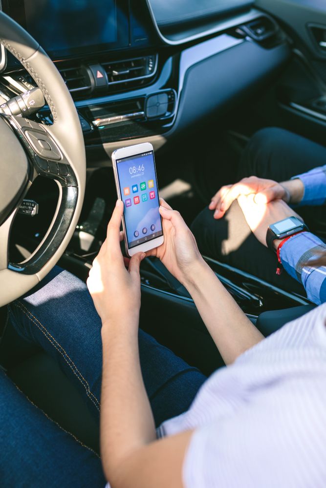 Woman and boyfriend using mobile in the car