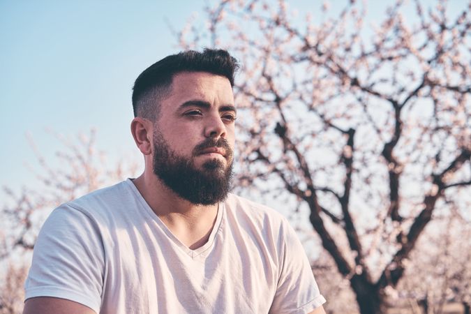 Bearded man meditating in spring garden